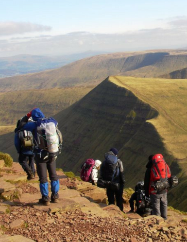 Participants walking down a steep mountain in the Brecon Beacons